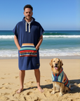 hooded dog towel, man on the beach wearing a surf poncho changing robe. Dog wearing same hooded dog towel