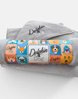 silver dog towel with colorful packaging branding displays 'Dolphin and Dog'. the dog towel is on display on a white background.