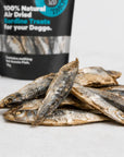 Close-up of whole air-dried sardine dog treats with the Boat To Bowl sardine treat bag in the background.