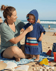 toddler at the beach with his mum, toddler is wearing a hooded towel designed by Dolphin and Dog
