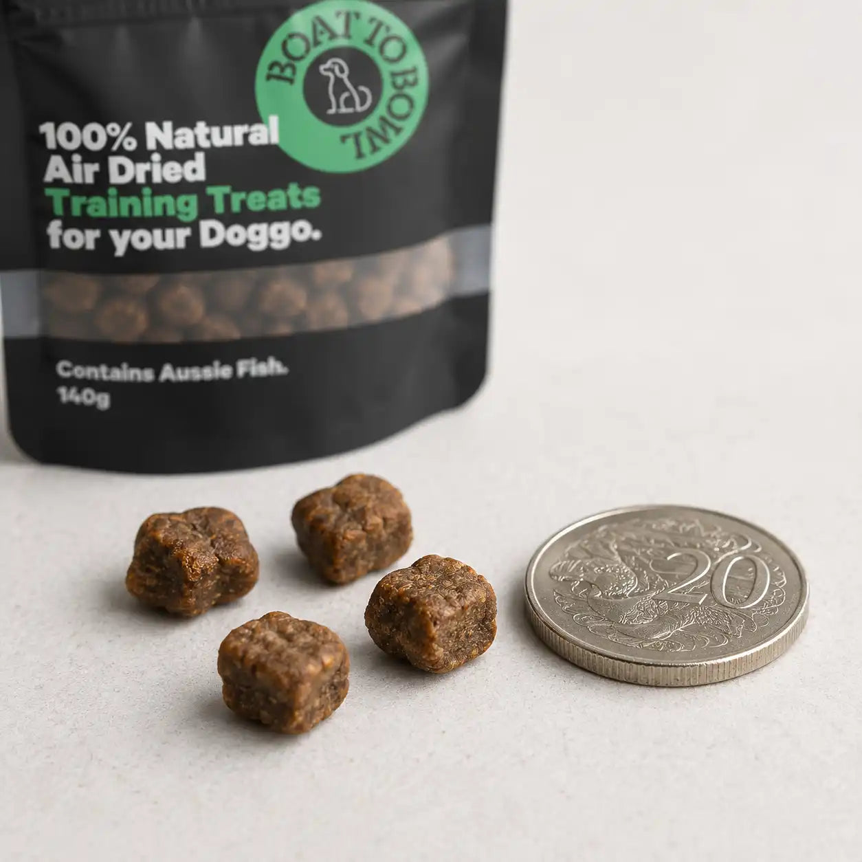 Small air-dried dog training treats shown beside an Australian 20 cent coin for size comparison.
