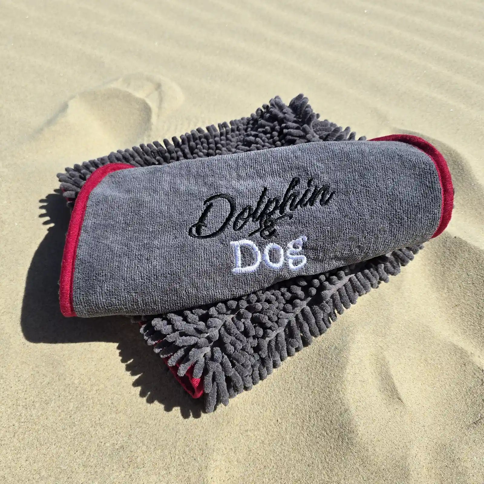 Close-up detail of the grey Dolphin &amp; Dog fast drying towel showing the logo and soft material texture.