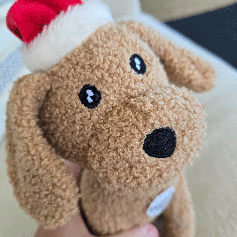 soft stuffed dog toy,  a brown dog with a Christmas hat on 