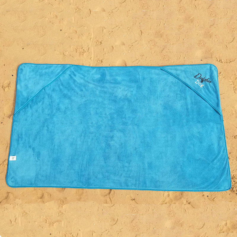 dog towel laid out on the beach showing it full size. corner pockets for hands to be placed