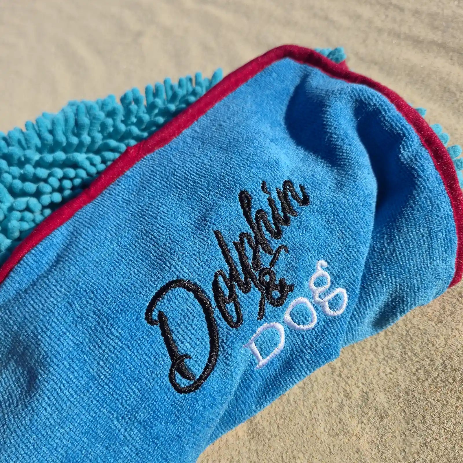 Close-up detail of the Dolphin & Dog logo and soft towel texture on the super absorbent dog towel