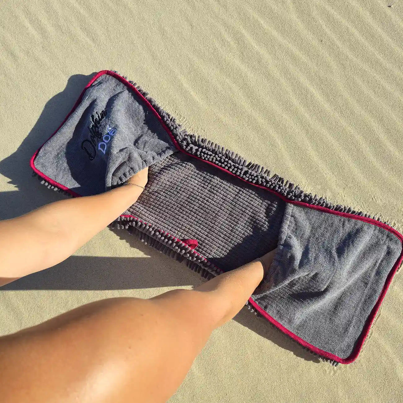 Demonstrating the corner hand pockets on the grey variant of the Dolphin &amp; Dog absorbent pet towel.