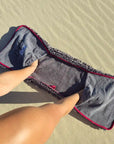 Demonstrating the corner hand pockets on the grey variant of the Dolphin & Dog absorbent pet towel.