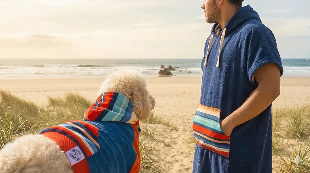 Fluffy dog in a colorful dog hoodie and dog jumper matching a human hooded towel set. High-quality, vibrant pet and owner twinning apparel.