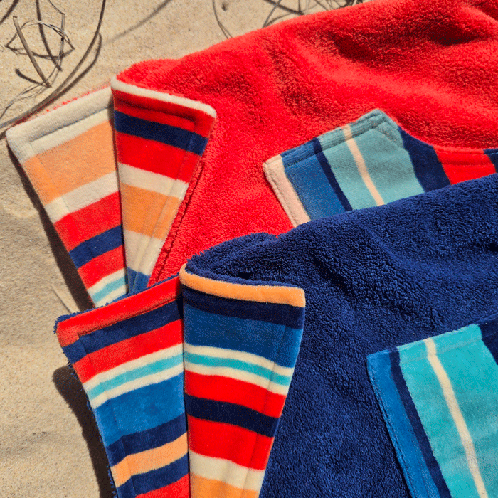 hooded beach towels, on the sand showing the reversible pattern 