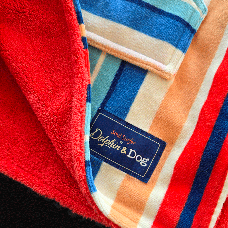 Close-up of a colorful kids towel with a brand label with &quot;Dolphin and Dog&quot; on a black background