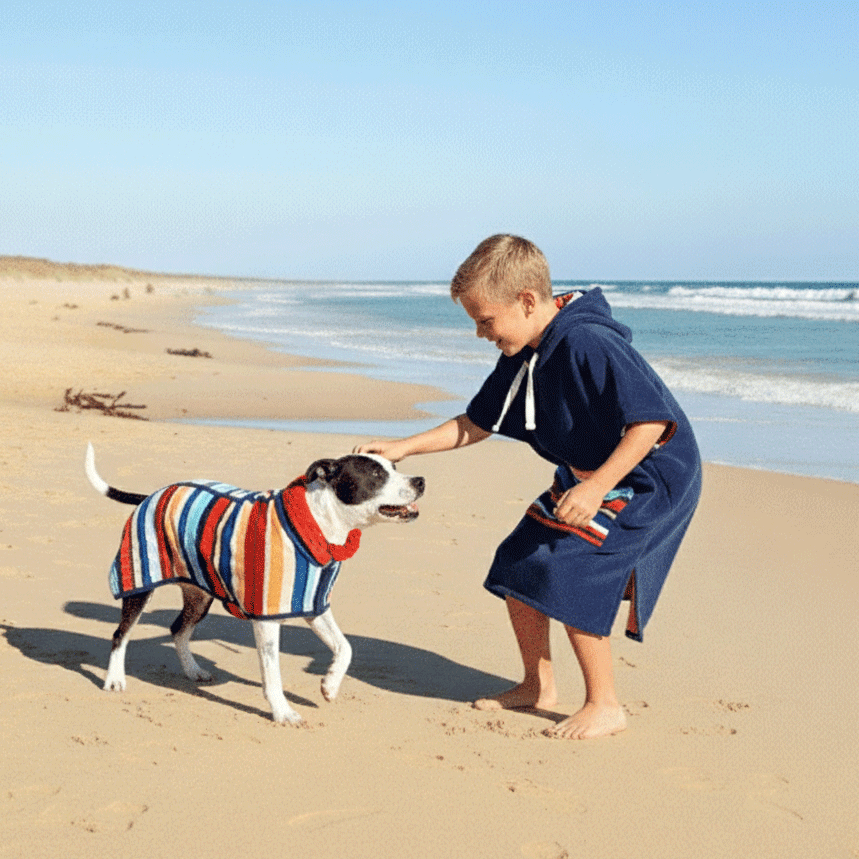 kid wearing a hooded towel playing with a dog that has a matching dog drying coat 