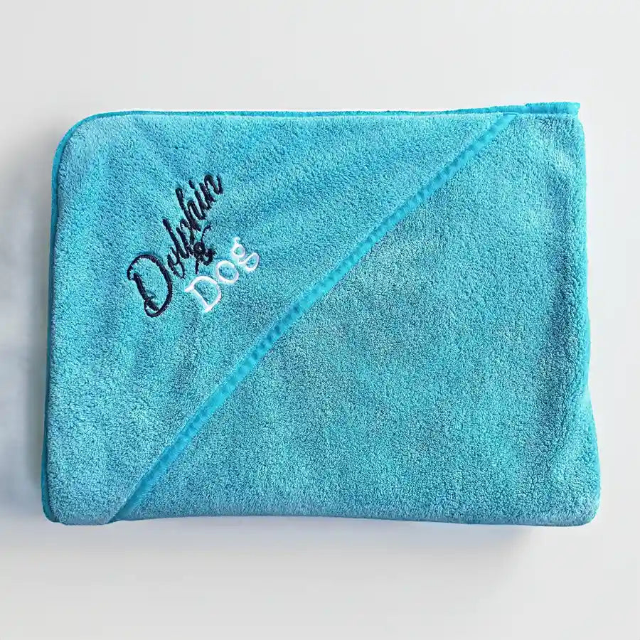 large dog towel with 'dolphin and dog' branding embroided on the hand pocket. towel is neatly folded 